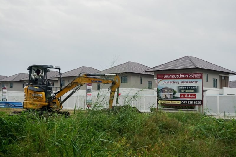2024年11月10日,一辆建筑车辆停在一个有许多中国居民居住的住宅区附近,旁边是一个广告空置房源的标牌,位于泰国清迈省杭东区。(Kanokphorn Janploy/BenarNews)