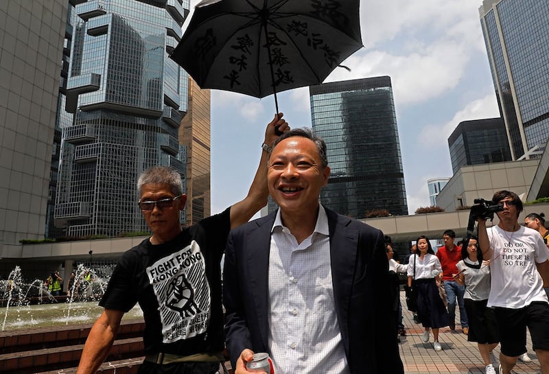 资料照:2019年8月15日,戴耀廷(中)离开香港高等法院。(美联社)
