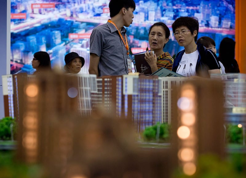 在北京房地产投资展览会上,人们观看展示的住房模型。(美联社)