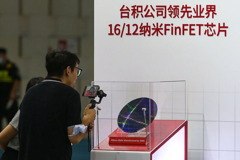 中芯国际落后于台积电技术约三代。图为2020年8月26日,南京举行2020年世界半导体大会上,一位访客为台积电(TSMC)的芯片拍照。(法新社)