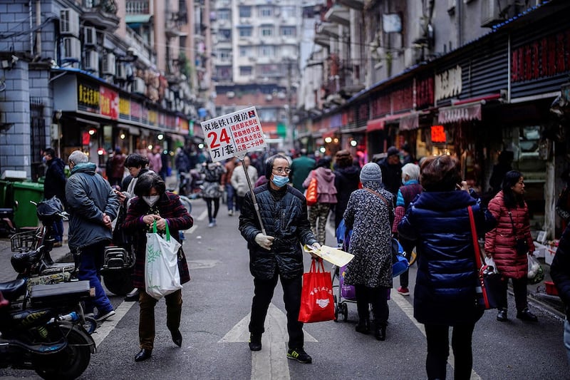 2020年12月7日，湖北省武汉市，新冠病毒爆发近一年后，一名男子在街上推销房子。（路透社）